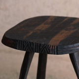 Wooden stool with a worn finish on a neutral background