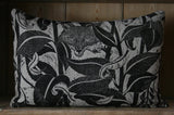 Decorative pillow with fox and leaf pattern on a wooden background