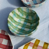 Colorful ceramic bowl on a checkered fabric background