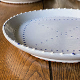 White ceramic plates with painted blue delftware decoration by Emily Mitchell