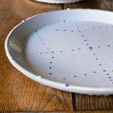 White ceramic plates with painted blue delftware decoration by Emily Mitchell
