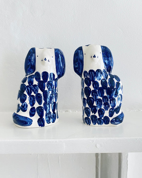 Two ceramic dog-shaped vases with blue and white pattern on a white surface.