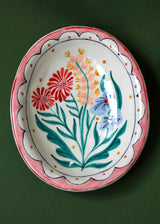 Ceramic plate with floral design on a green background