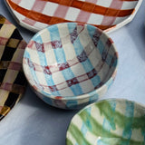 Set of ceramic bowls with checkered patterns on a light gray surface