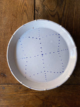 White ceramic plates with painted blue delftware decoration by Emily Mitchell