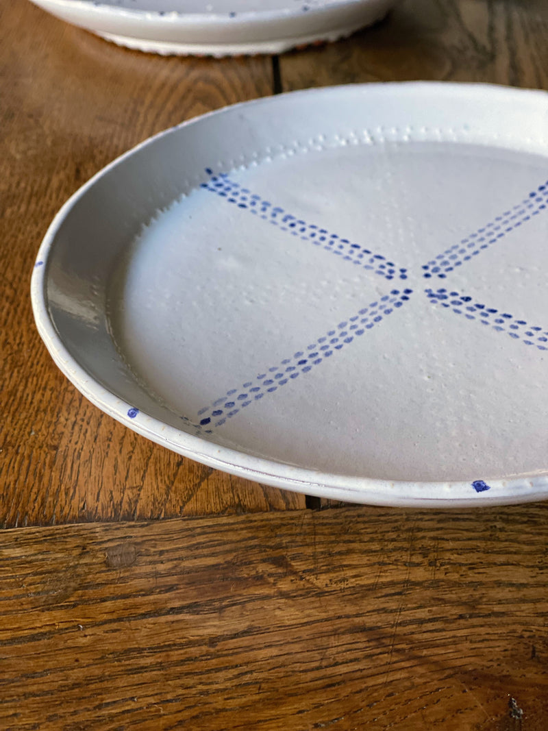 White ceramic plates with painted blue delftware decoration by Emily Mitchell