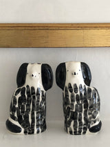 Two ceramic dog-shaped vases with black and white pattern on a light background